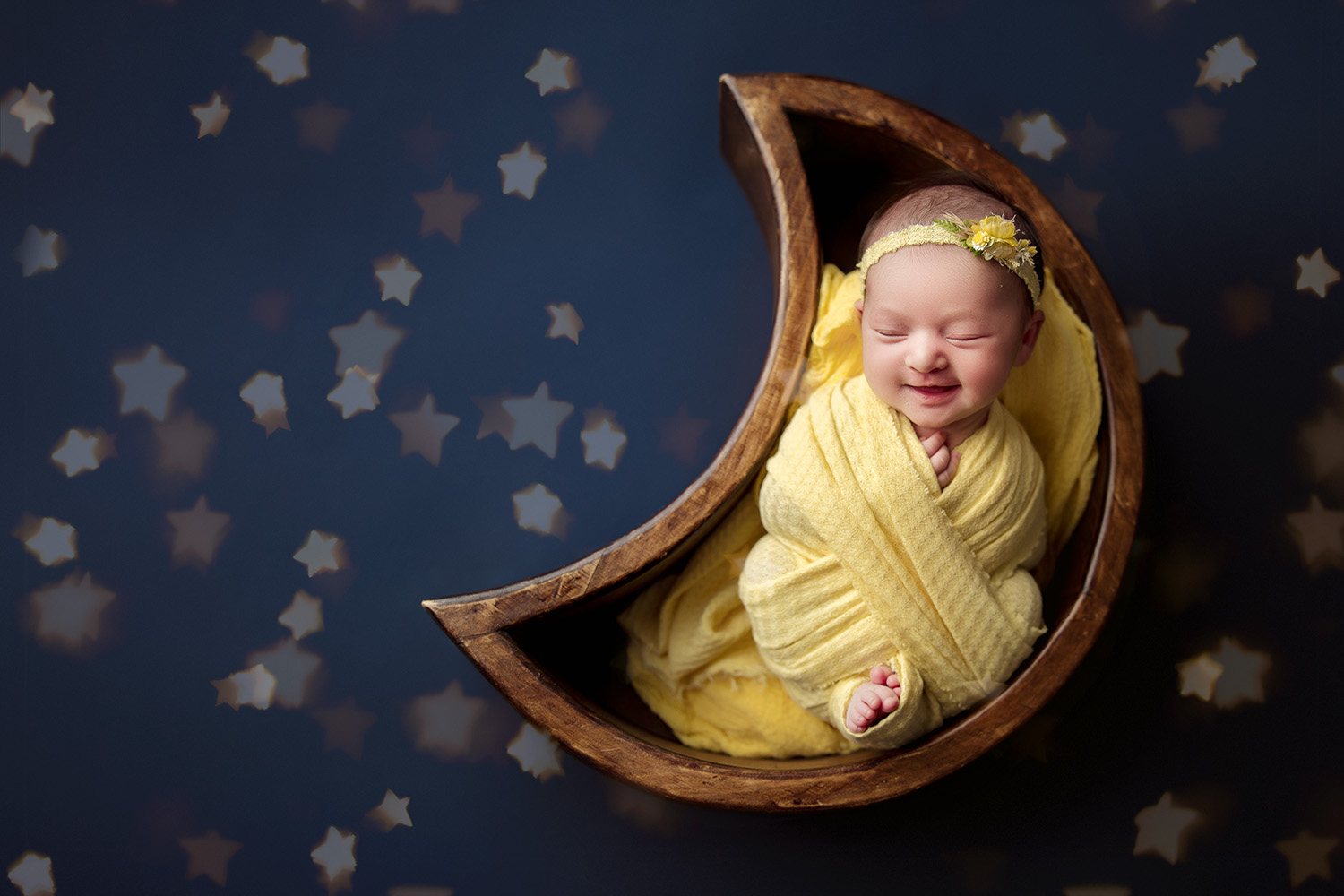 sleeping-newborn-baby-girl-smiling-laying-in-moon-shaped-bowl-during-newborn-photo-session-Greensboro-newborn-photographer-studio