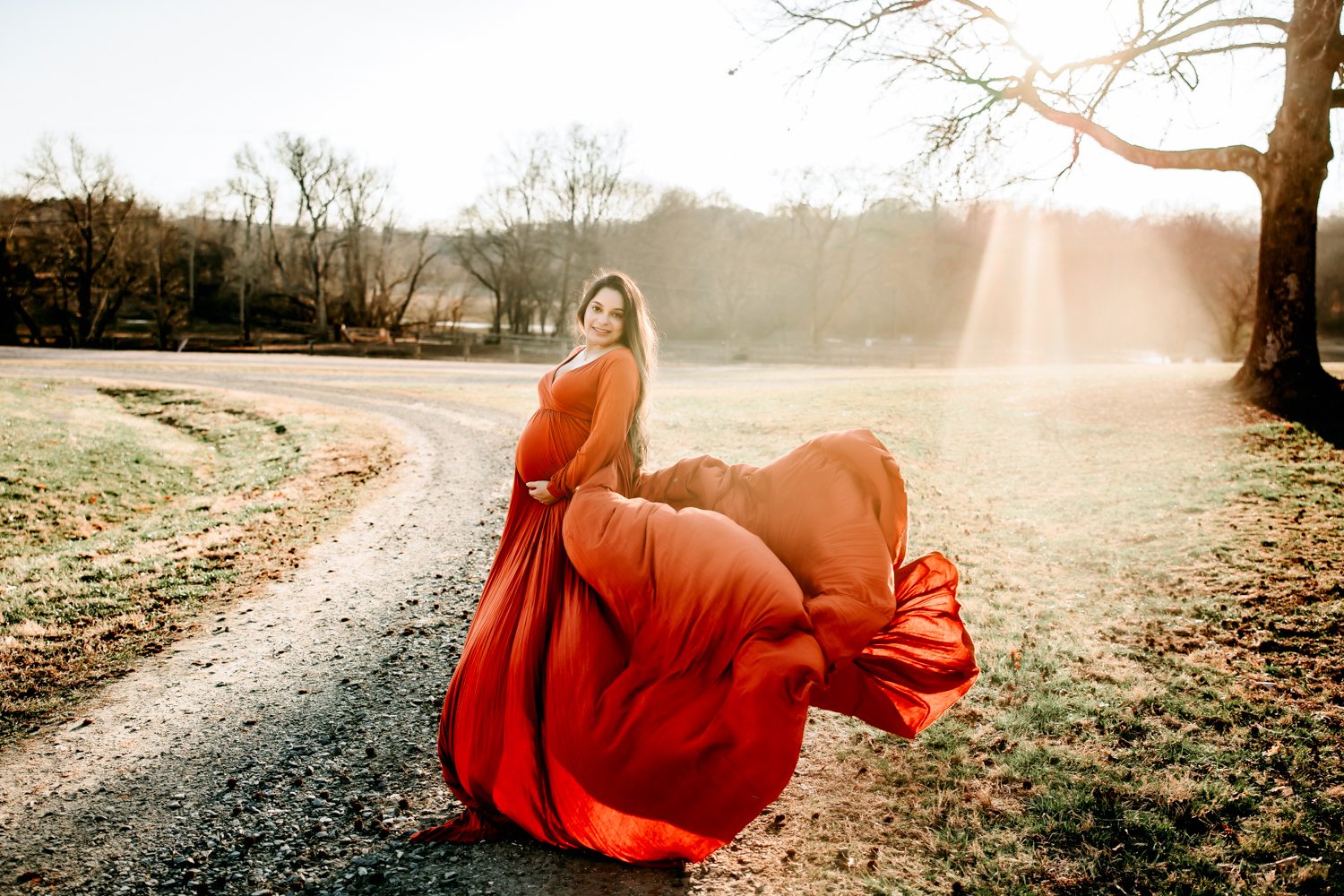 expectant mother in orange flowy dress in the golden sun during Tanglewood part Clemmons photoshoot
