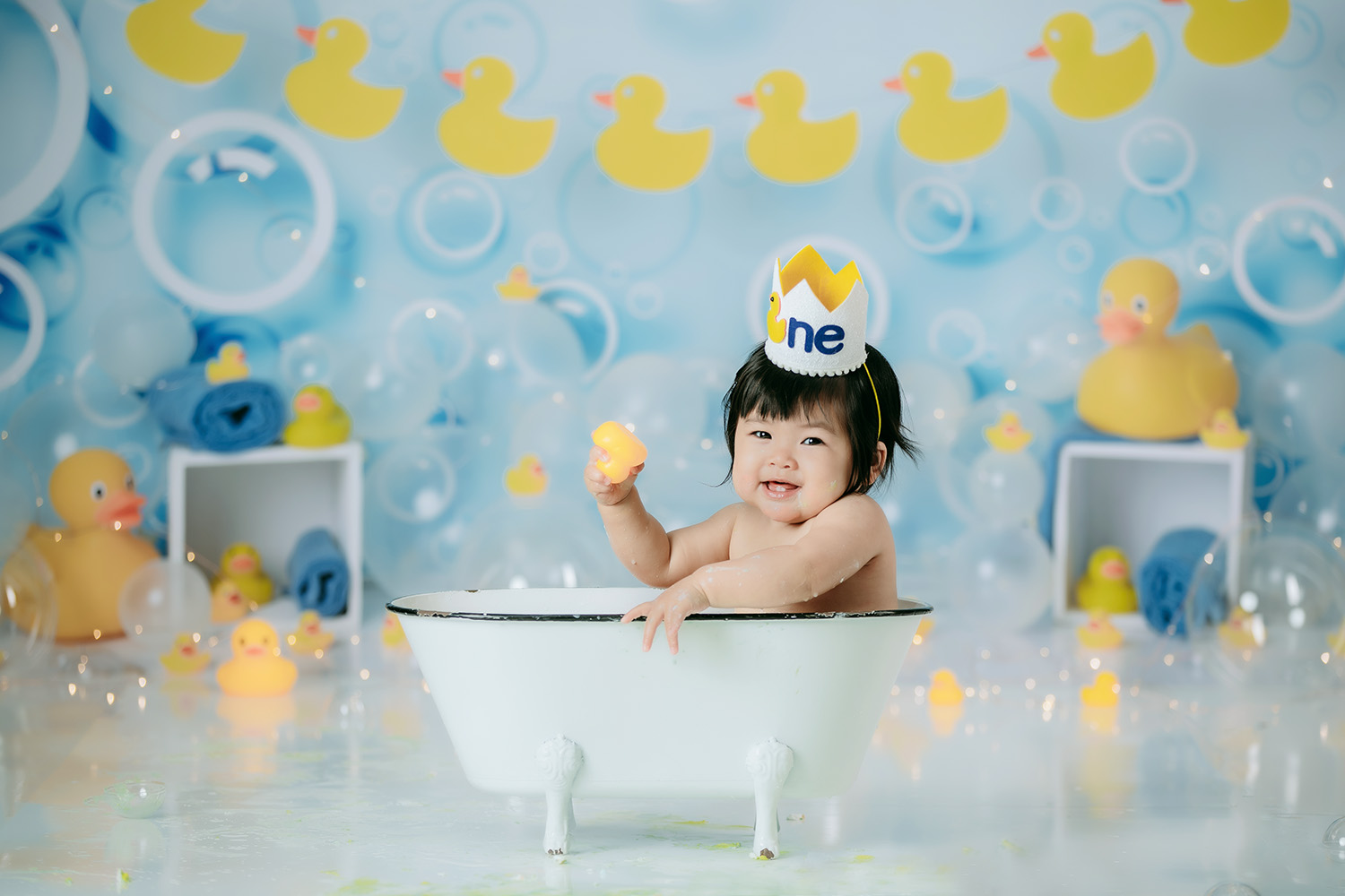cute-baby-girl-in-bathtub-during-winston-salem-cake-smash-photo-session-rubber-duckie-theme
