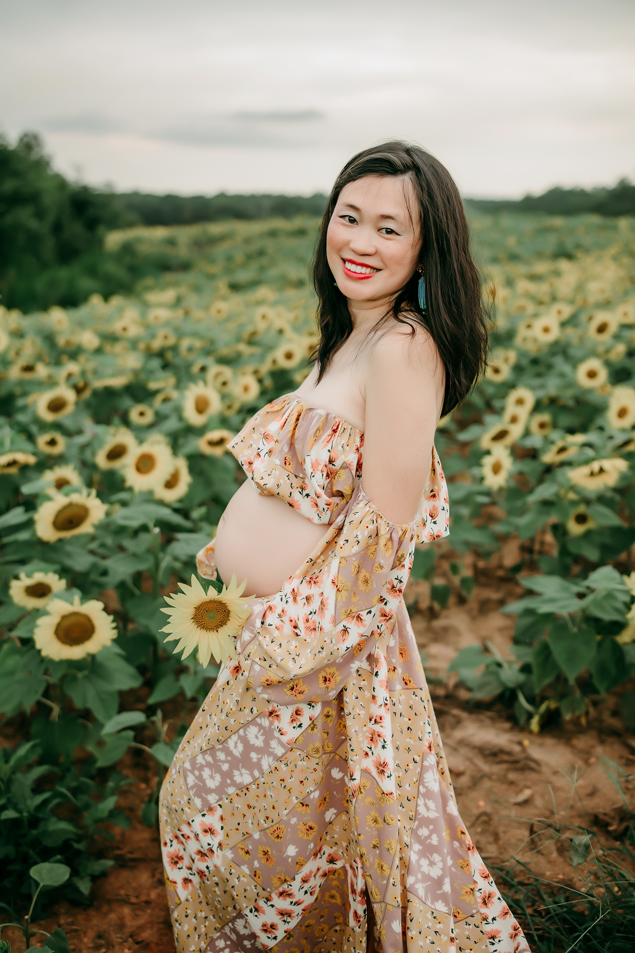 maternity-photo-shoot-mama-wearing-floral-maternity-dress-in-sunflower-field-greensboro-maternity-photography-session