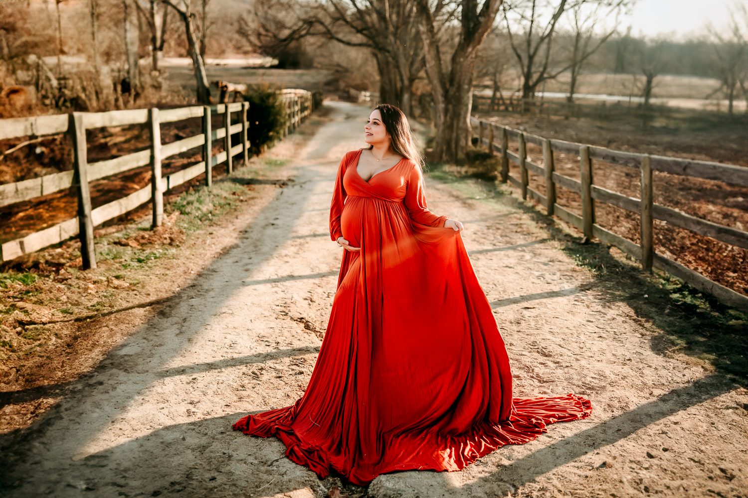 maternity woman in rust orange gown during maternity-photography-at-tanglewood-park-Winston-salem