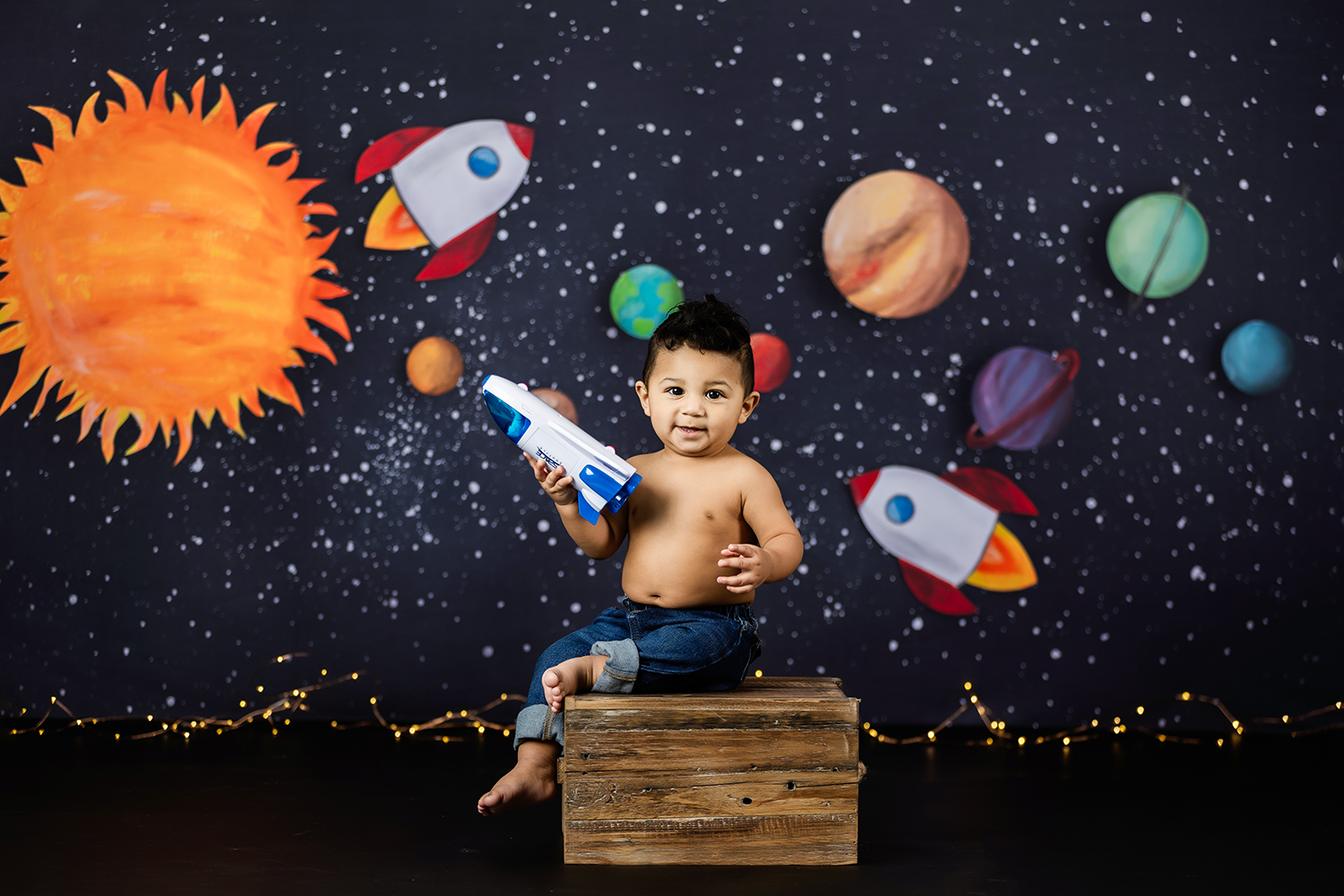 out-space-themed-first-birthday-session-baby-boy-holding-a-toy-airplane-greensboro-cake-smash-photoghrapher