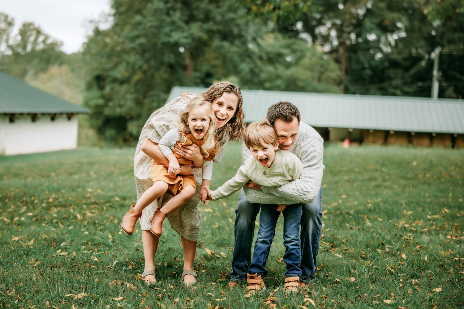 family-of-4-laughing-and-hugging-during-family-photo-session-in-Tanglewood-Park-Clemmons-North-carolina-family-photography