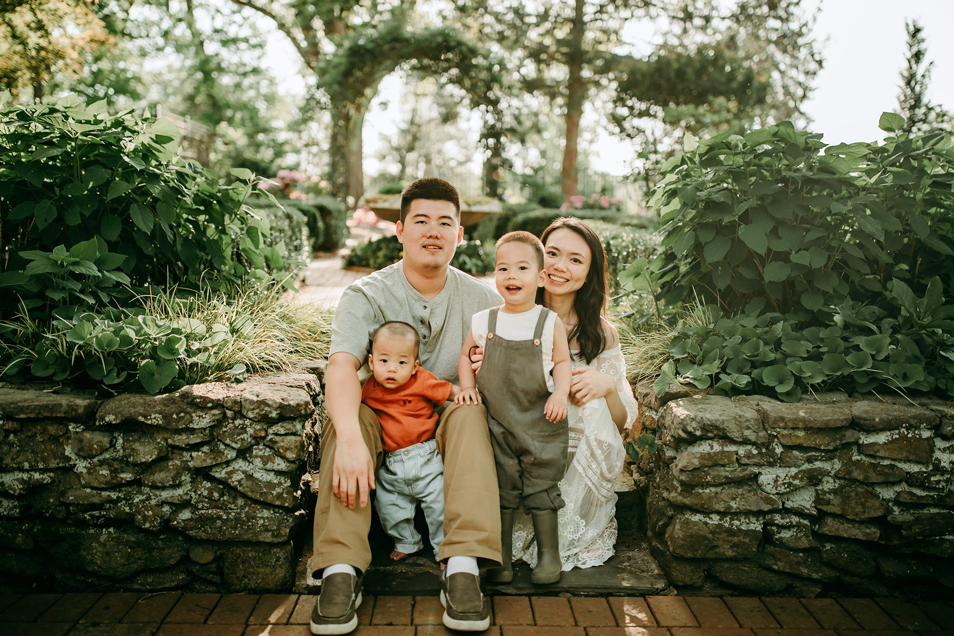 family-of-4-sitting-on-the-stairs-during-family-photo-session-in-Tanglewood-botanical-garden