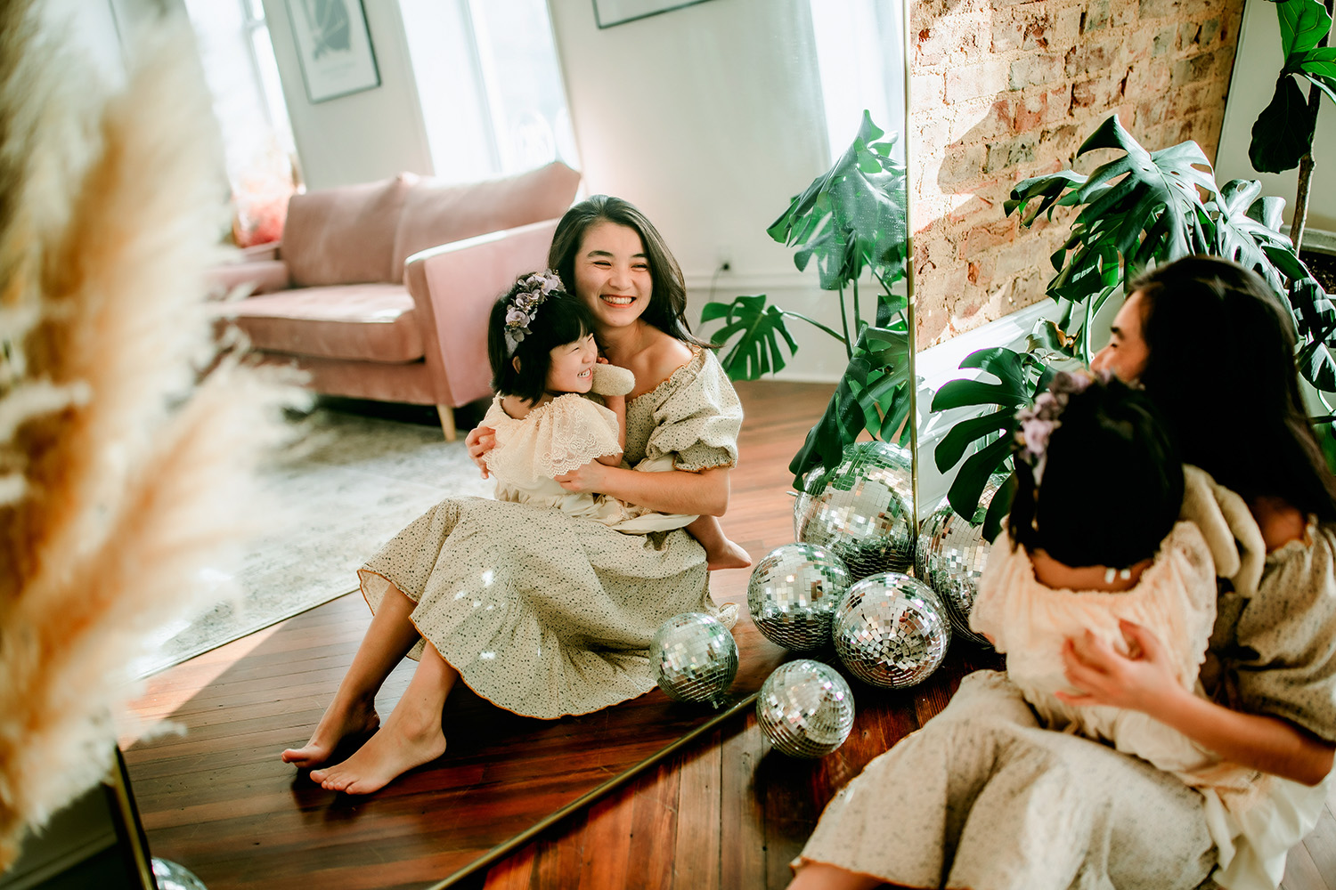 mommy-and-daughter-sitting-in-front-of-mirror-cuddling-during-mommy-and-me-session-downtown-winston-salem-family-photography-session