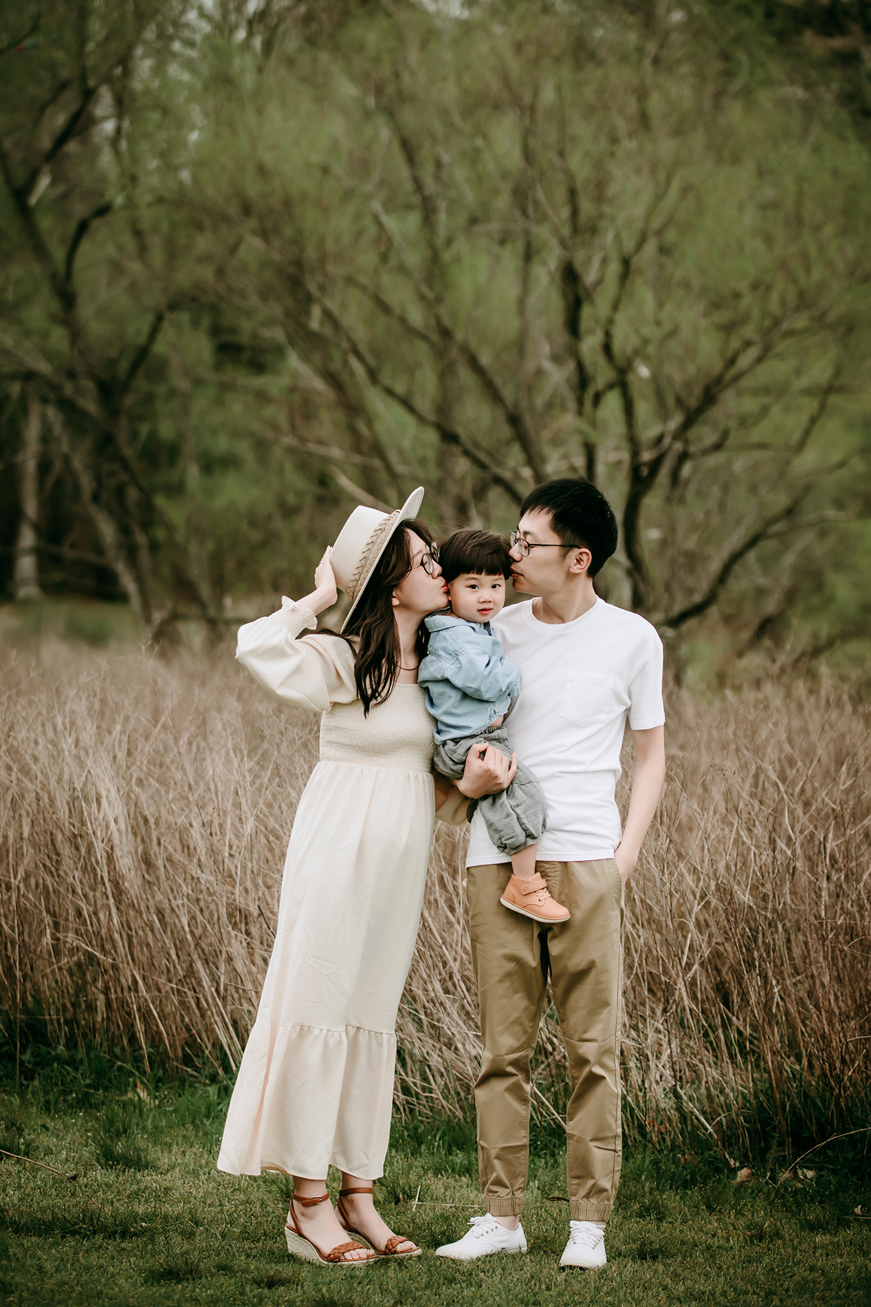 parents-kissing-baby-boy-during-family-photo-session-at-Lake-Crabtree-Raleigh-NC-family-photography
