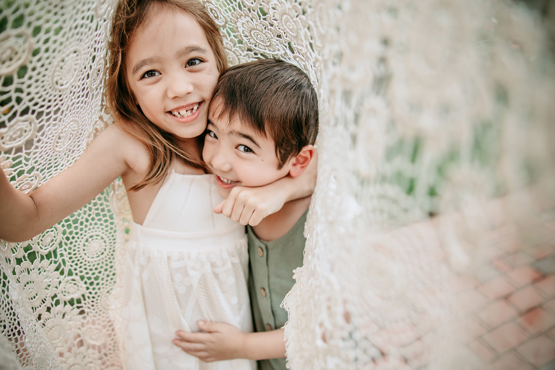 sister-and-brother-hugging-under-the-blanket-during-family-photo-session-charlotte-family-photography