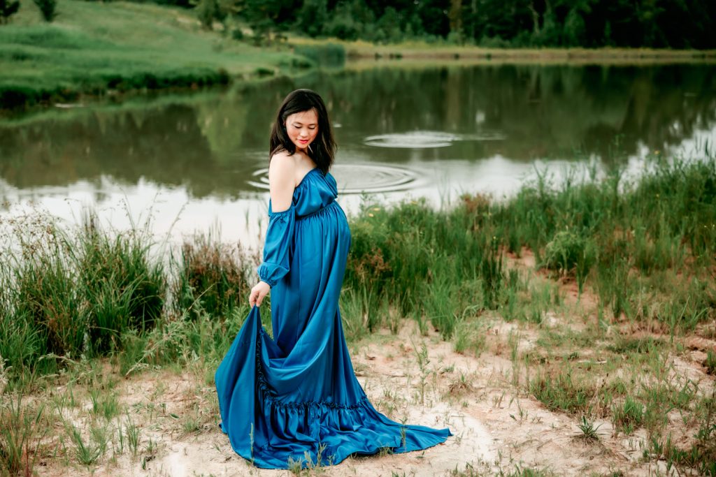 beautiful maternity mother by the pond in a dark teal dress in Dogwood Farms Belews Creek north carolina maternity photo session