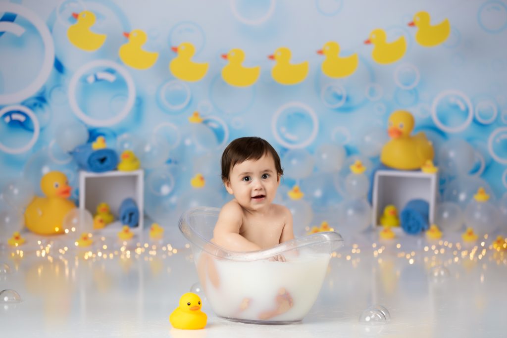 baby in milk bath during rubber Duckie cake smash session in winstons salem