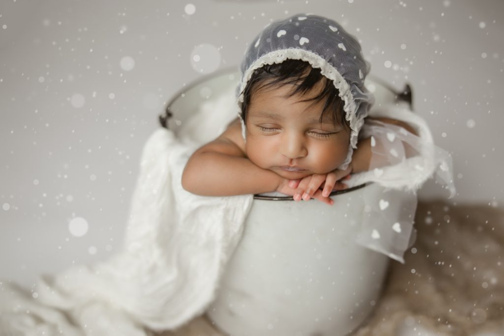newborn baby girl sleeping in white bucket prop during greensboro newborn photo studio