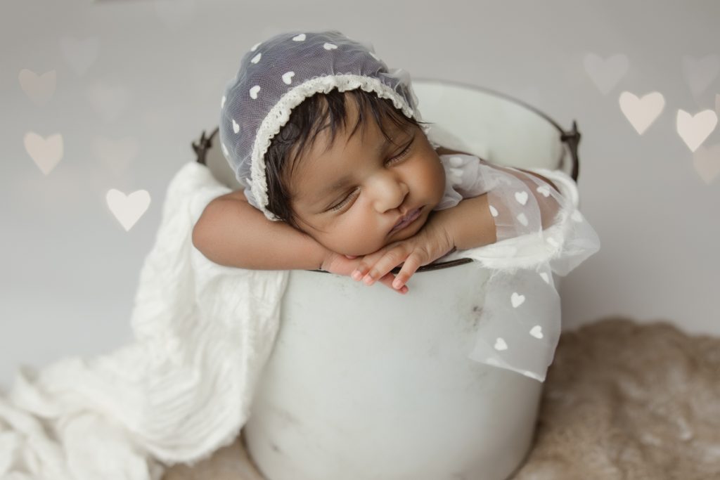 newborn baby girl sleeping in white bucket prop during greensboro newborn photo studio