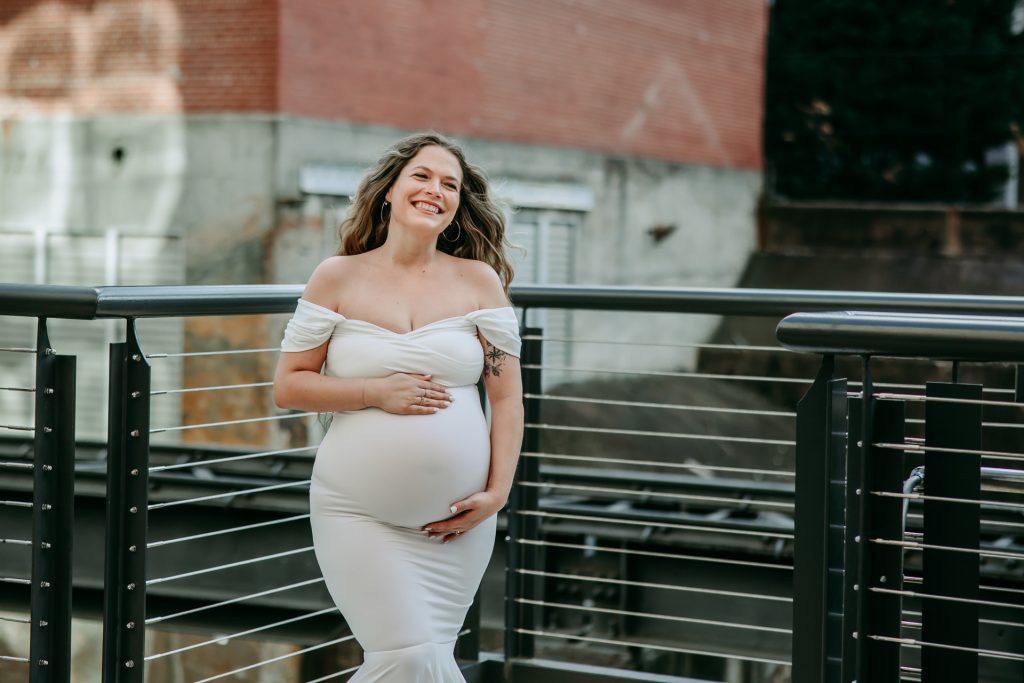 Maternity mother in white gown in industrial background downtown winston-salem North Carolina maternity photo session