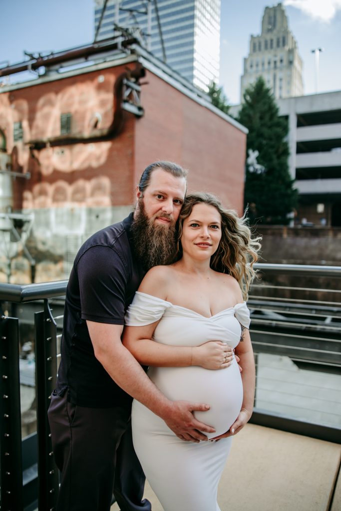 Maternity mother in white gown with husband in industrial background downtown winston-salem North Carolina maternity photo session
