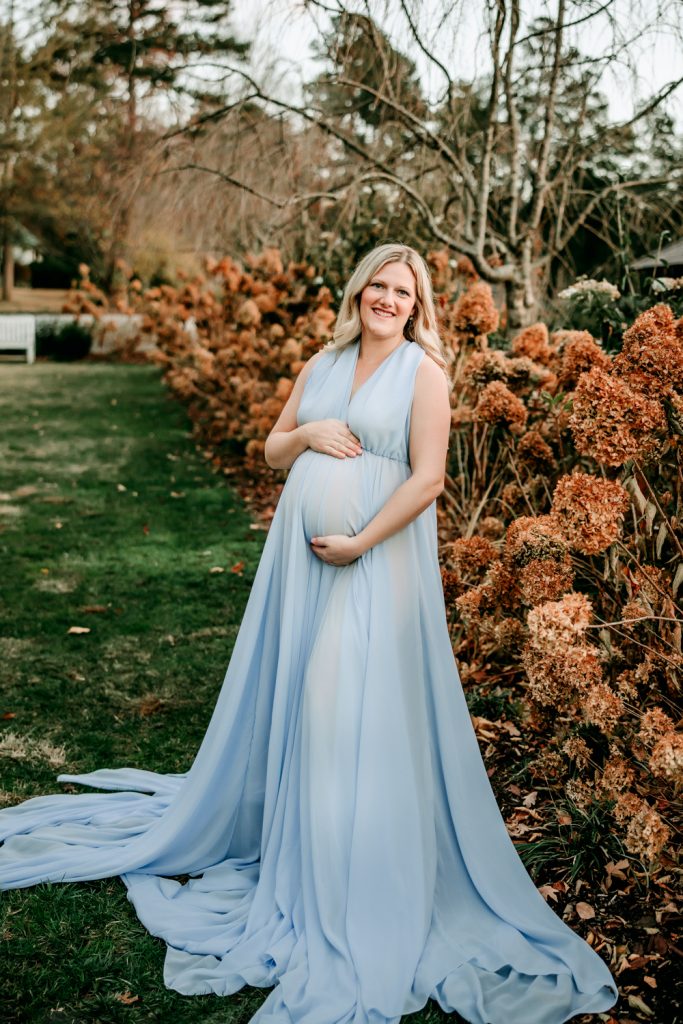 maternity mother in blue chiffon dress during family photo session at Reynolda garden and museum