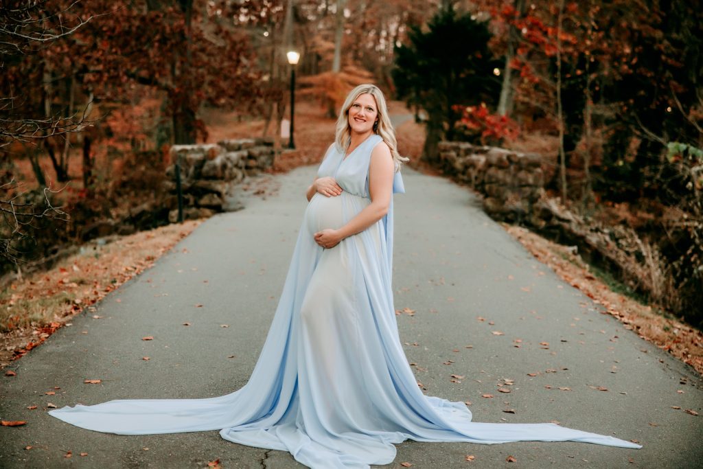 maternity mother in blue chiffon dress during family photo session at Reynolda garden and museum