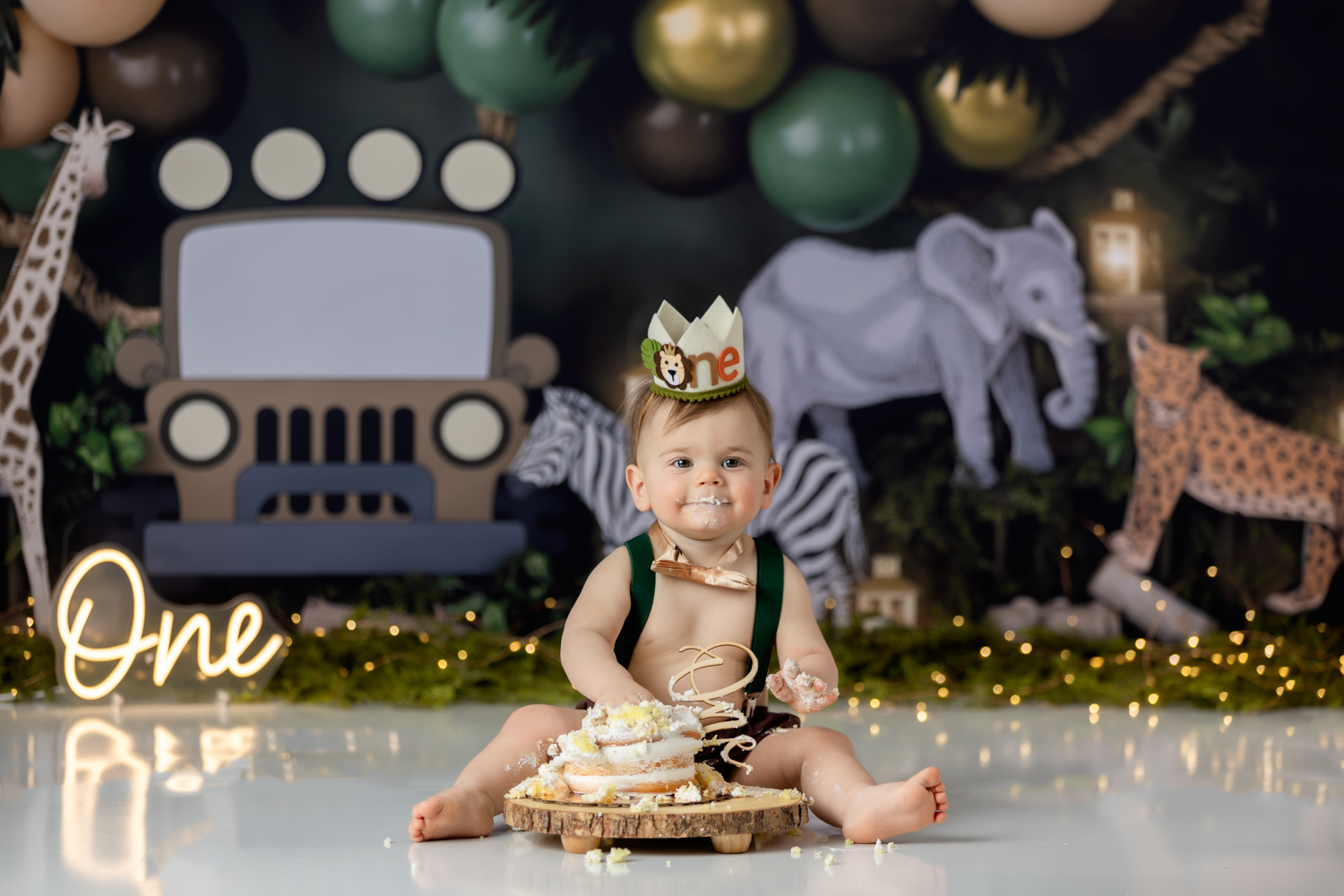 baby boy eating his birthday cake during wild one themed cake smash photo session with greensboro baby photographer