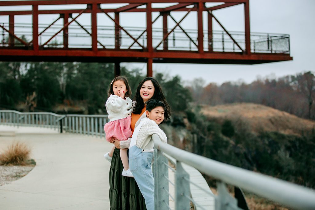 mom-with-boy-and-girl-in-front-of-the-iron-bridge-during-family-photoshoot-at-quarry-park-winston-salem-nc