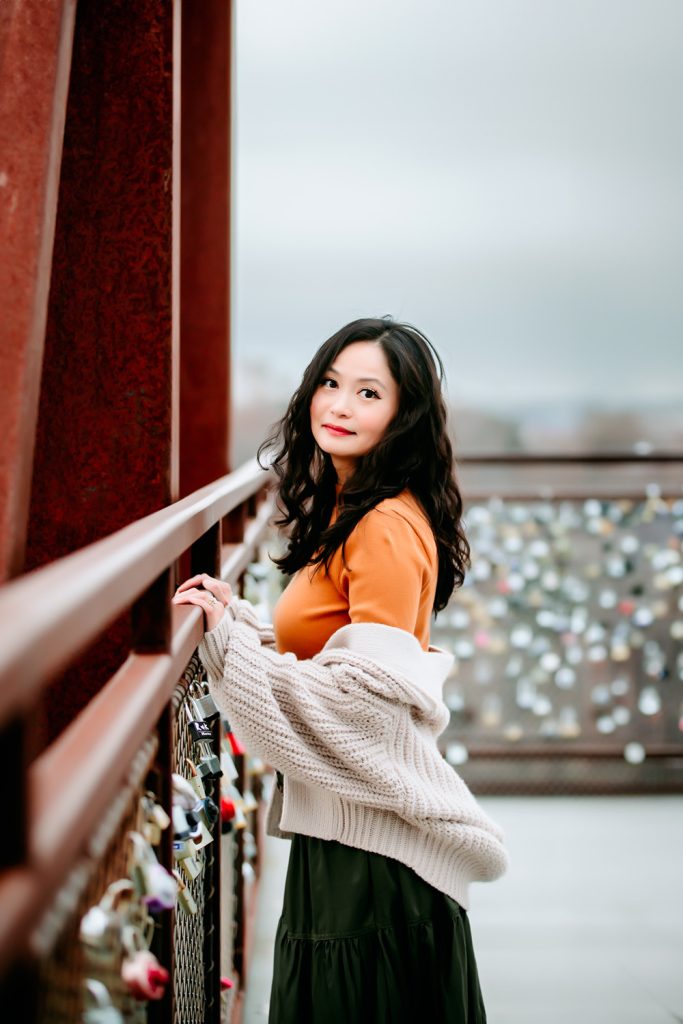 women-in-knit-cardigan-leaning-on-the-bridge-during-family-photo-session-in-quarry-park-winston-salem