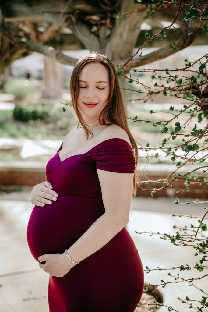 maternity mother in elegant fitted dress during maternity photo session in tanglewood arboretum Winston Salem NC