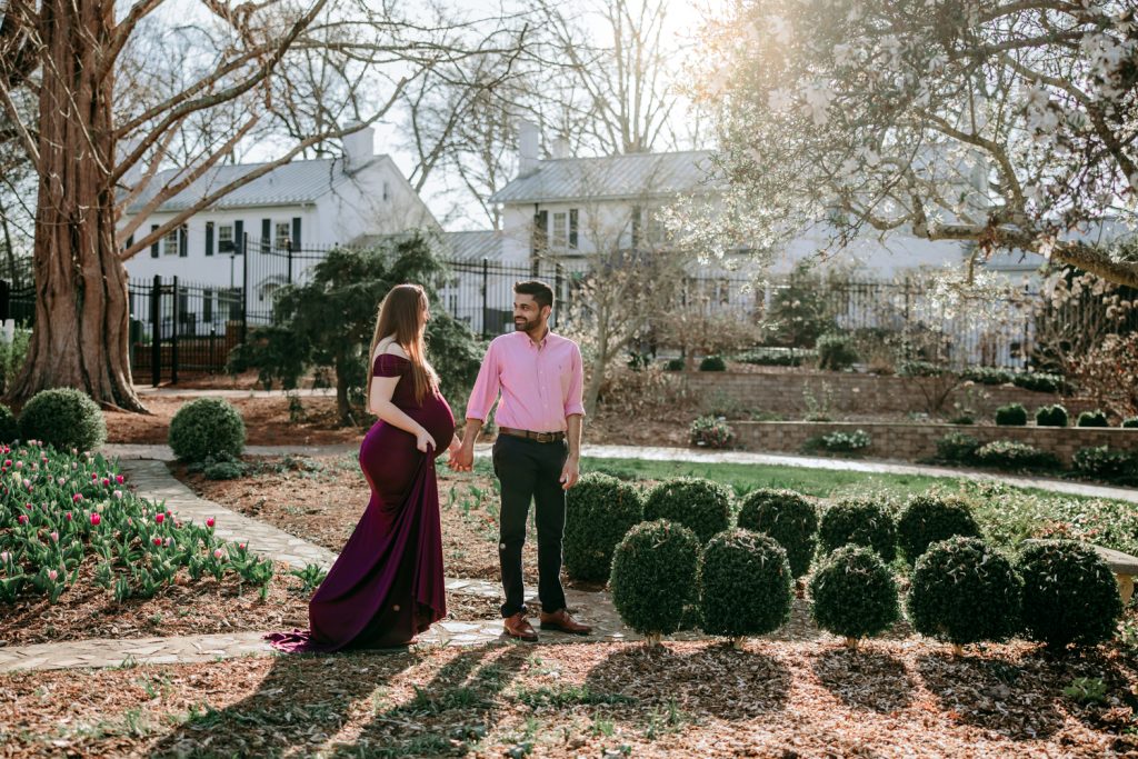 maternity mother in elegant fitted dress with her husband during maternity photo session in tanglewood arboretum Winston Salem NC