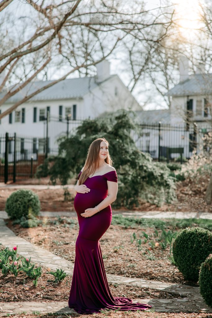 maternity mother in elegant fitted dress during maternity photo session in tanglewood arboretum Winston Salem NC