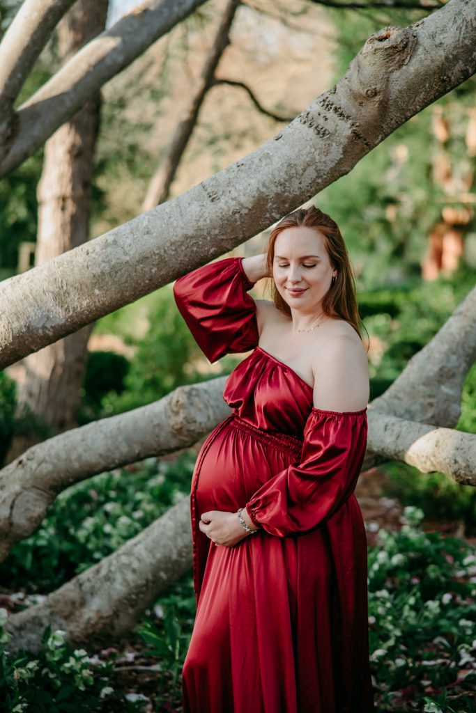 beautiful-expectant-mother-in-flowy-silky-gown-in-tanglewood-park-garden-during-maternity-photo-session-with-winston-salem-motherhood-photographer