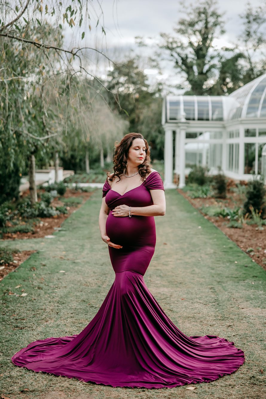 beautiful maternity mother in berry color mermaid gown at Reynolda garden Winston Salem during maternity photo session