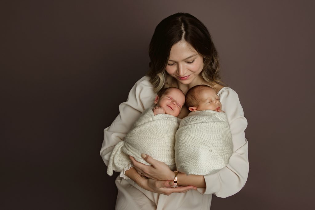 mother-holding-newborn-baby-twins-with-her-toddle-son-in-family-photo-during-winston-salem-newborn-photo-session