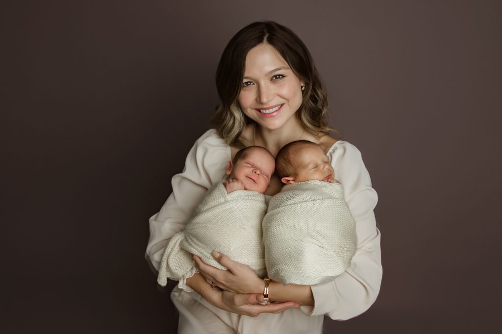 mother-holding-newborn-baby-twins-with-her-toddle-son-in-family-photo-during-winston-salem-newborn-photo-session
