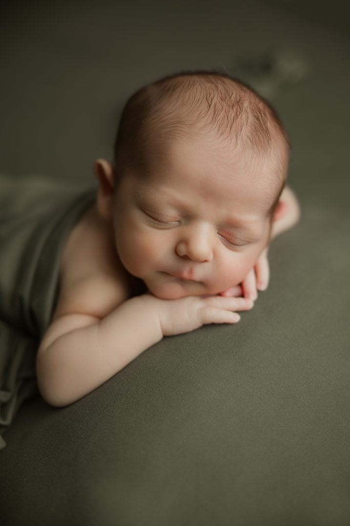newborn-baby-boy-soundly-sleeping-on-green-blanket-during-winston-salem-newborn-photography-session