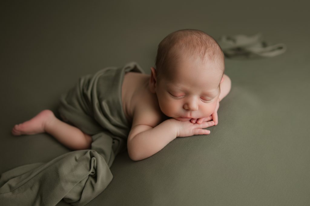 newborn-baby-boy-soundly-sleeping-on-green-blanket-during-winston-salem-newborn-photography-session