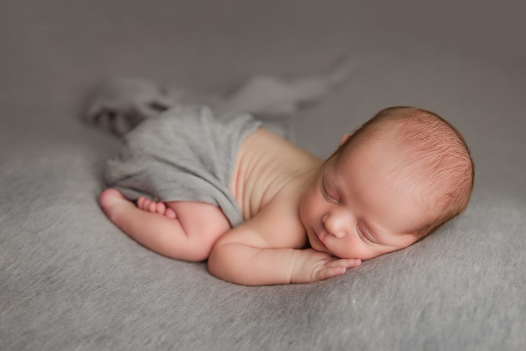 newborn-baby-boy-soundly-sleeping-on-grey-blanket-during-winston-salem-newborn-photography-session