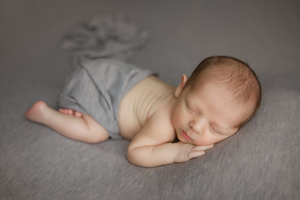 newborn-baby-boy-soundly-sleeping-on-grey-blanket-during-winston-salem-newborn-photography-session