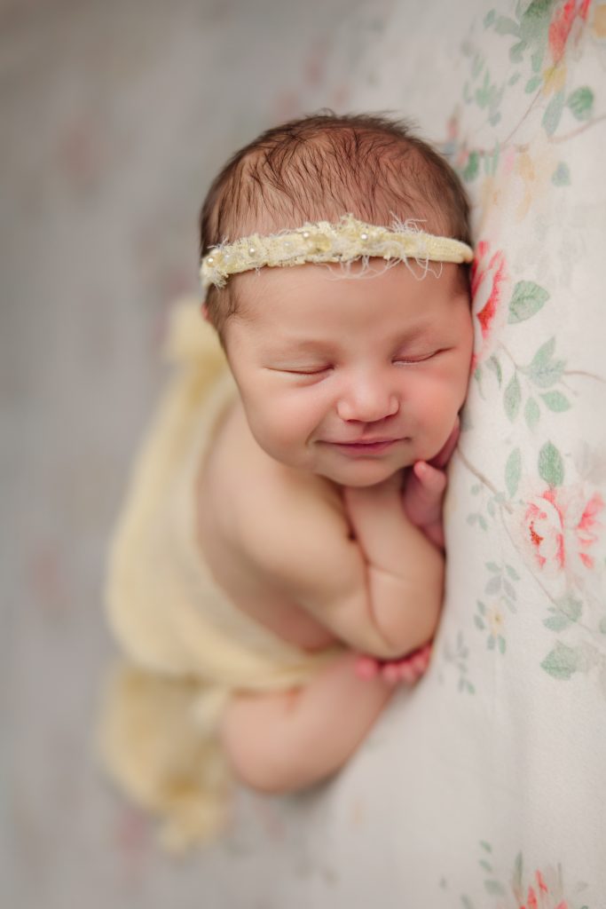 newborn-baby-girl smiling in sleep during-photo-session-winston-salem-newborn-photography