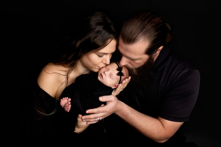 parents-holding-newborn-baby-girl-closing-eyes-during-winston-salem-newborn-photo-session