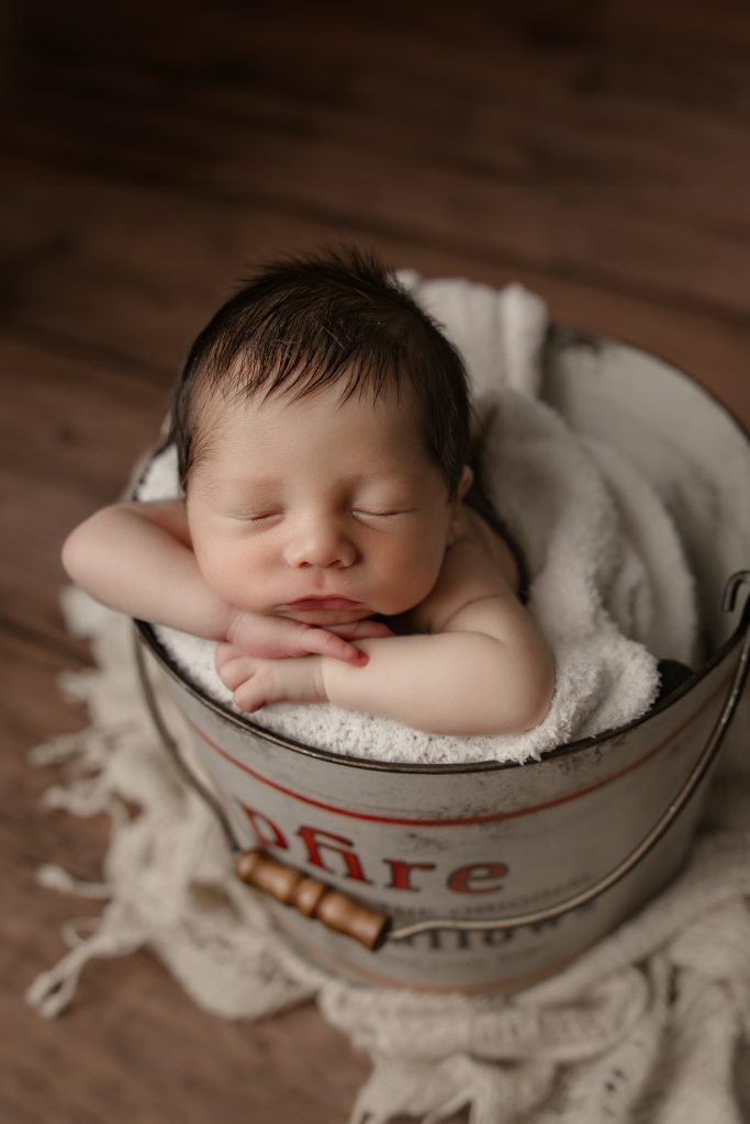 newborn-baby-sleeping-in-bucket-photo-prop-during-greensboro-newborn-photoshoot