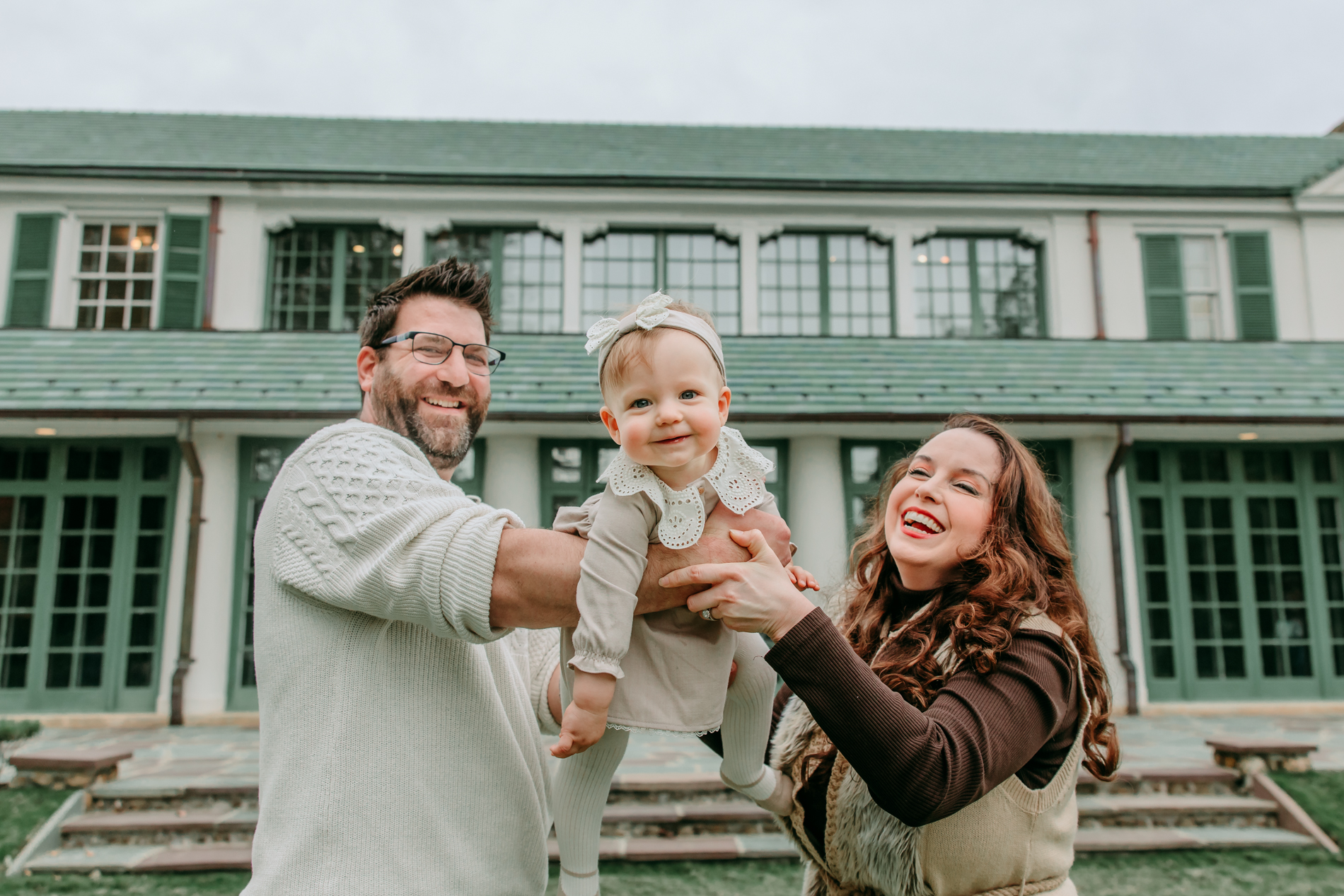 parents-holding-baby-girl-during-reynolda-garden-family-session-with-winston-salem-family-photographer