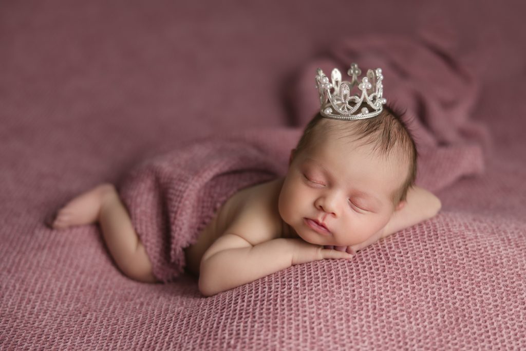 newborn-baby-girl-photo-session-in pink background and pink outfit and a pearl crown with-winston-salem-newborn-photographer