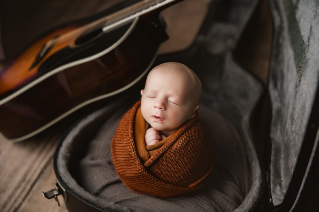 newborn-baby-boy-sleeping-in a guitar case-during-greensboro-newborn-photography-photoshoot