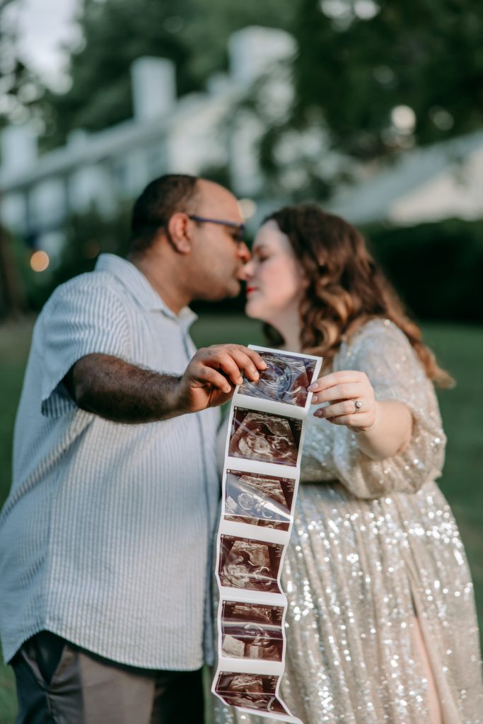 parents-holding-ultrasound-photo-during-pregnancy-annoucement-tanglwood-park-clemmons-north-carolina-winston-salem-family-photographer